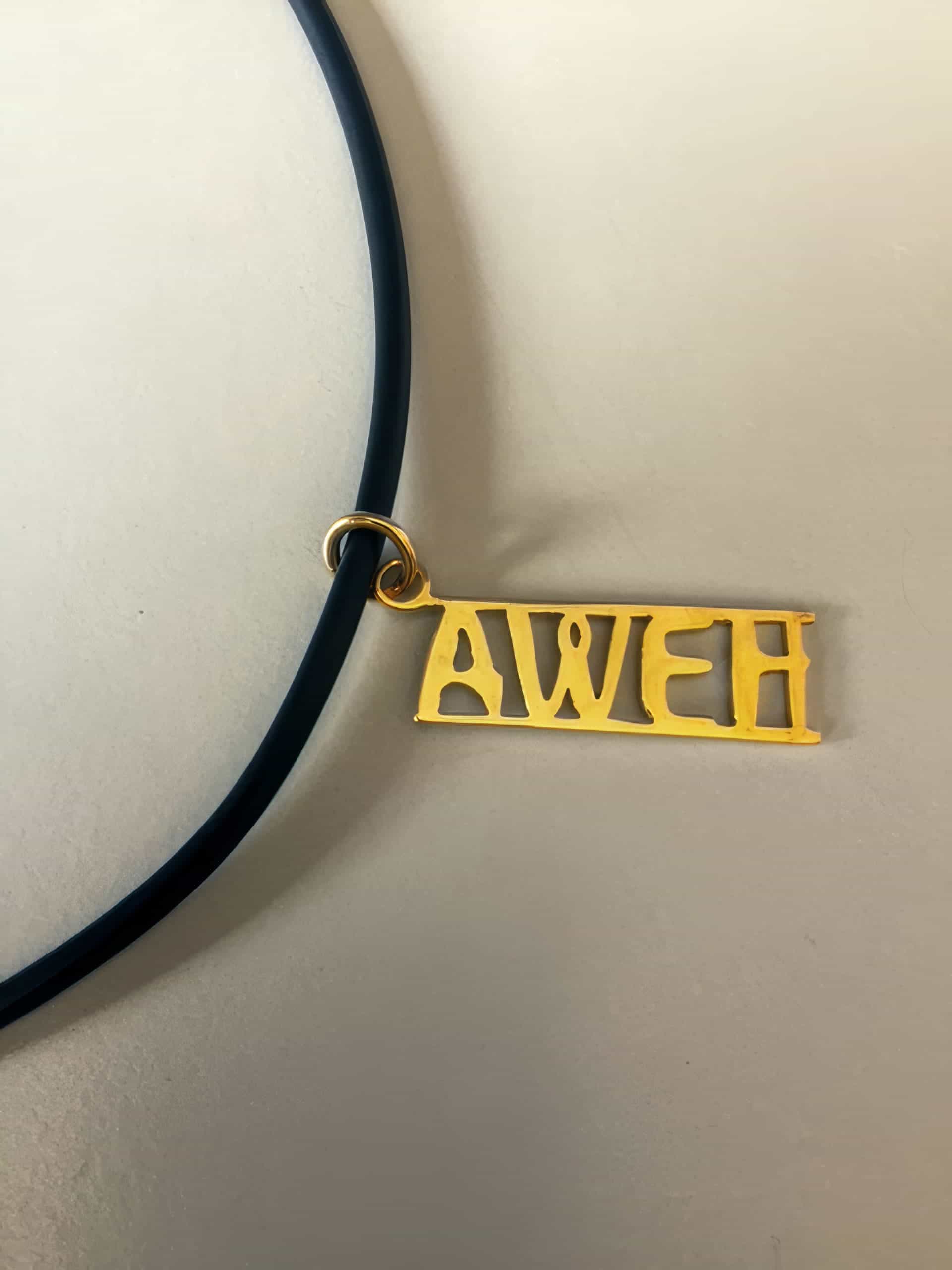 A gold rectangular pendant with the word 