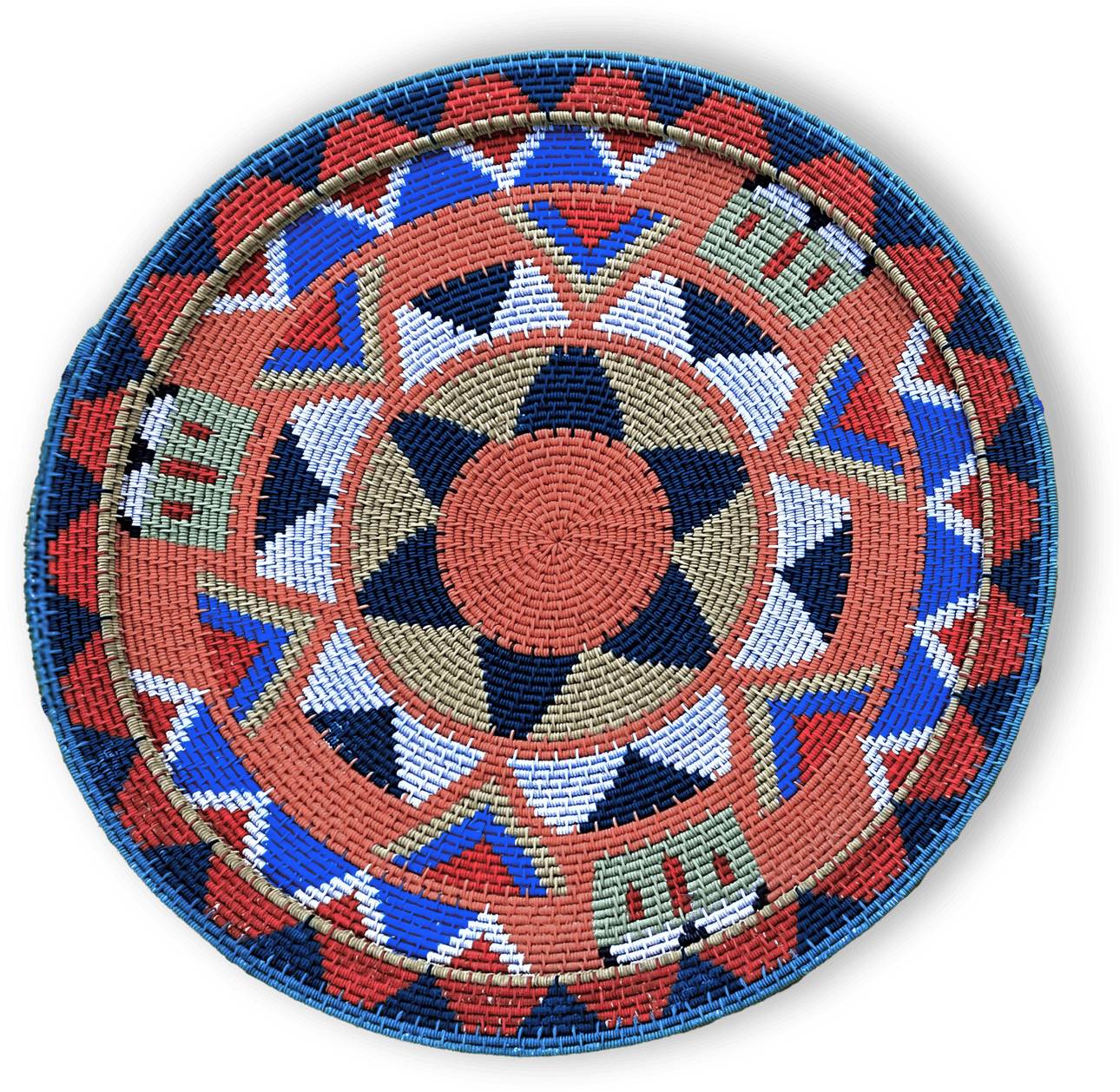 A round, woven basket lid with a geometric pattern in red, blue, tan, white, green, and black. It features star shapes, triangles, and rectangles, all arranged symmetrically around the centre, with a braided blue edge. The background is black.