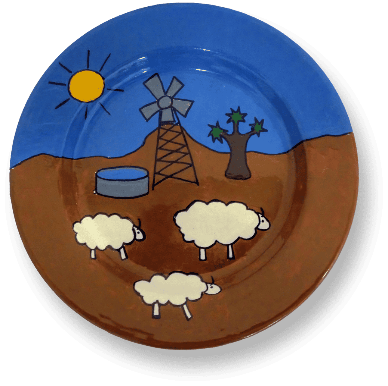 A plate features a desert scene with three cartoon sheep, a lone tree, a blue water tank, a windmill, and a yellow sun with rays, all set against a blue sky and brown ground. The design is simple and playful, using bold lines and solid colours.