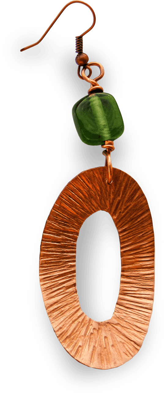 A single earring with a hook, featuring a textured, oval-shaped copper pendant and a small, glossy green bead above it. The copper component has engraved lines radiating outward, while the green bead is square and semitransparent.