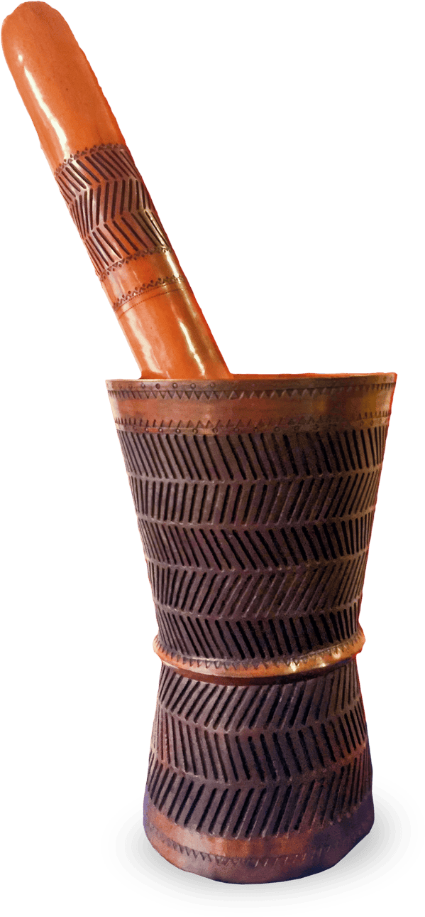 A tall, wooden mortar and pestle with intricate, geometric carvings in a zigzag pattern. The mortar is cylindrical and slightly flared at the base and rim. The pestle is smooth and rounded, both are polished and reddish-brown in colour.