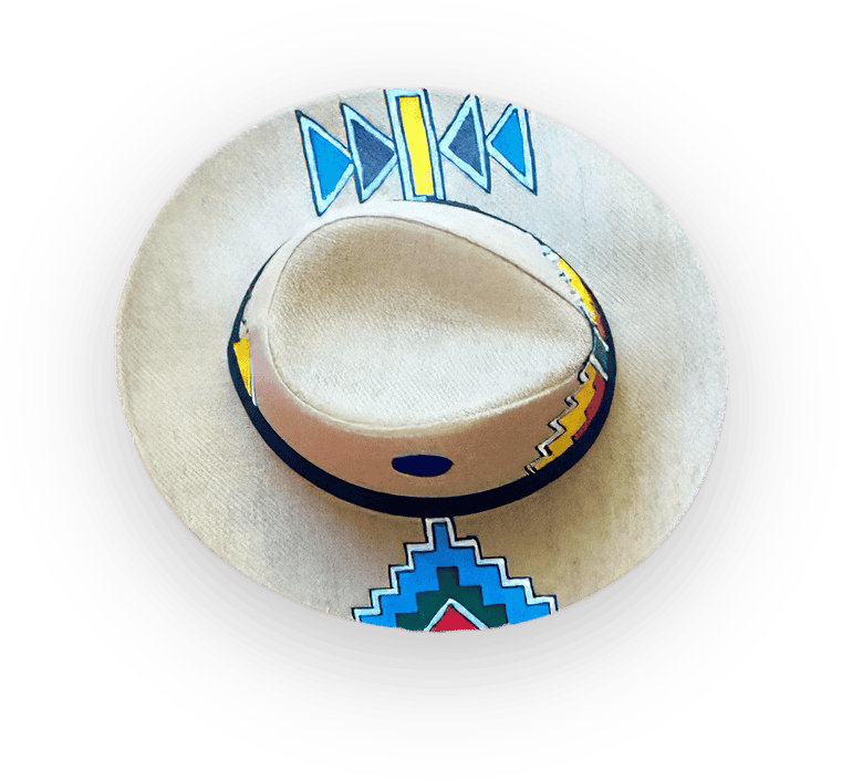 A light tan, wide-brimmed hat with hand-painted geometric patterns in blue, yellow, red, and green on the brim and crown, viewed from above against a solid black background. The patterns suggest Indigenous or Southwestern design influences.