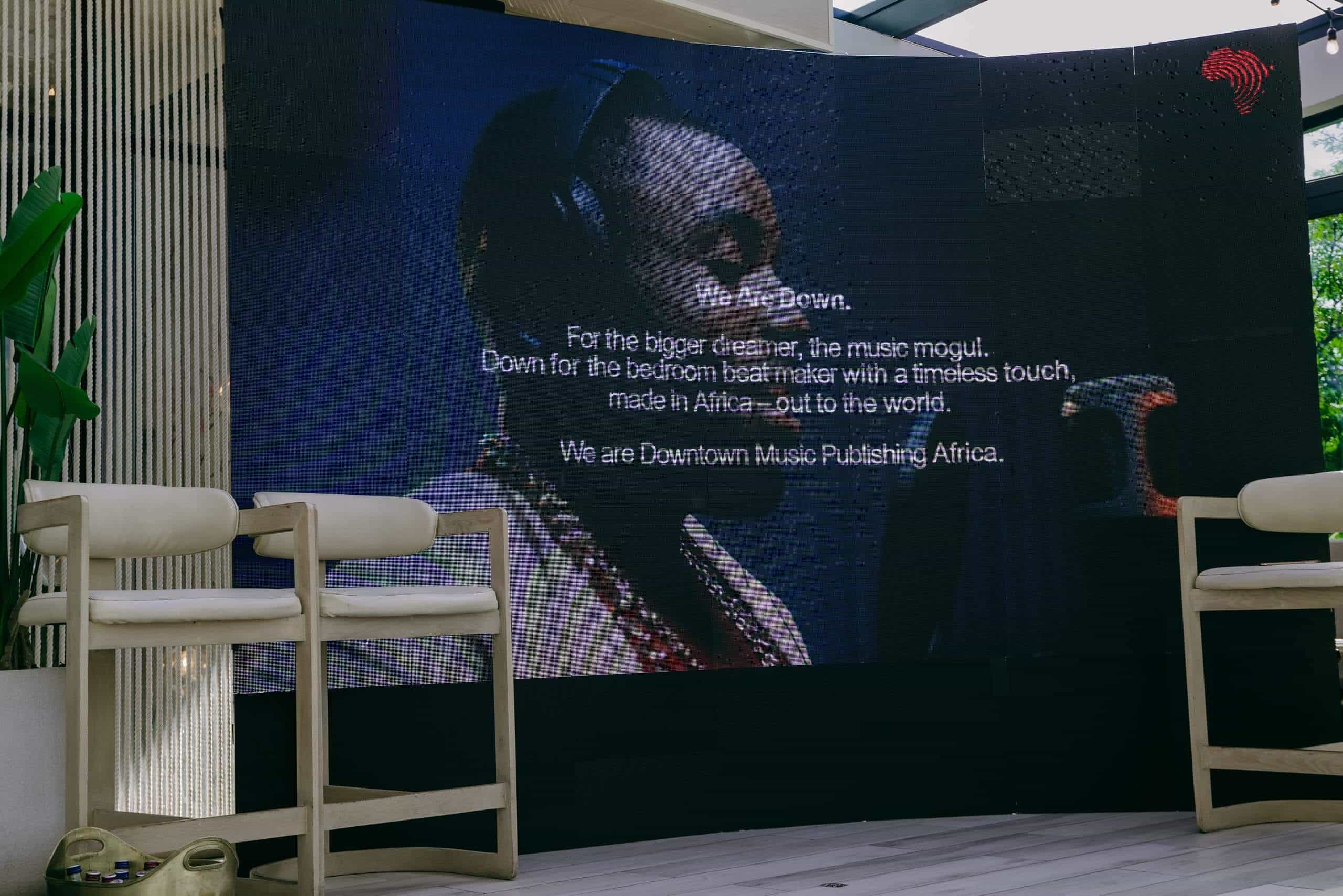 A large screen displays a photo of a man recording music, with the text: 